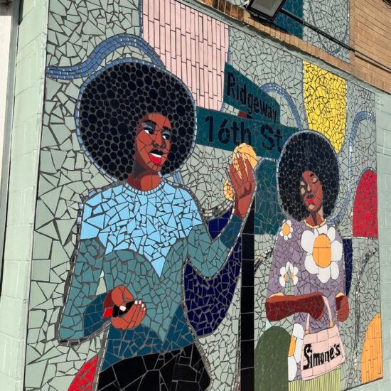 Mosaic mural art of a woman standing at a street sign